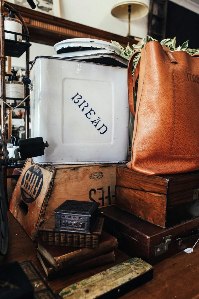 pexels-photo-5865339-5865339 A collection of vintage containers, books, and a leather bag on a wooden table.